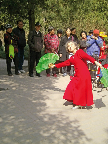 Kan Peixuan, 86, the oldest member of The Voice of Heart, dances at Jingshan Park. Wang Tingting / China Daily