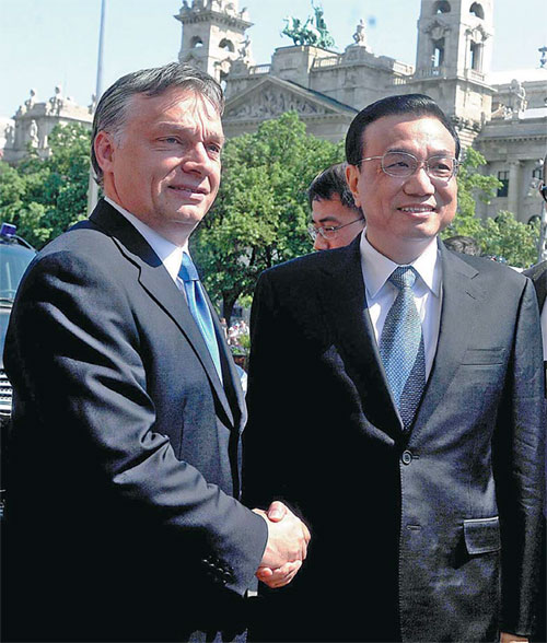 With the parliament building providing an elegant backdrop, Hungarian Prime Minister Viktor Orban greets Vice-Premier Li Keqiang in Budapest on Tuesday. [Imre Foldi/Associated Press-MTI]