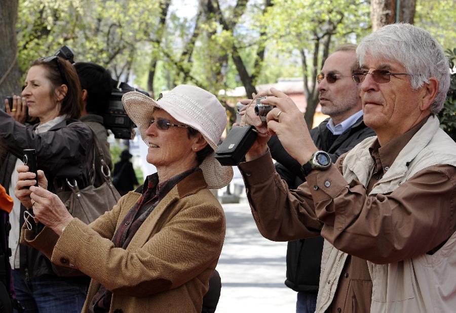 Foreign tourists shoot the performance of Tibetan Opera at Norbulingka Park in Lhasa, capital of southwest China's Tibet Autonomous Region, May 1, 2012. The traditional Tibetan Opera performance attracted lots of citizens and tourists during the May Day holidays. (Xinhua/Chogo) 