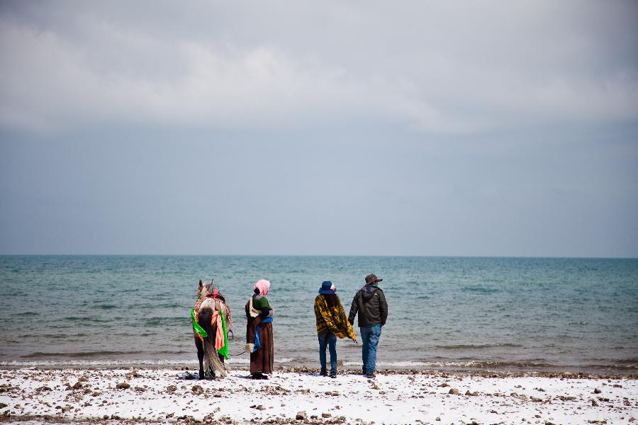 Tourists walk along the Qinghai Lake in northwest China's Qinghai Province, April 30, 2012. (Xinhua/Wu Gang) 
