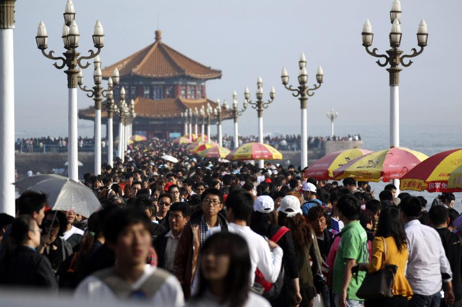 The seashore is swarmed with tourists in Qingdao City, east China's Shangdong Province, April 30, 2012. As weather warms, a good many people choose to spend the three-day Labor Day holiday in travelling. (Xinhua/Huang Jiexian) 