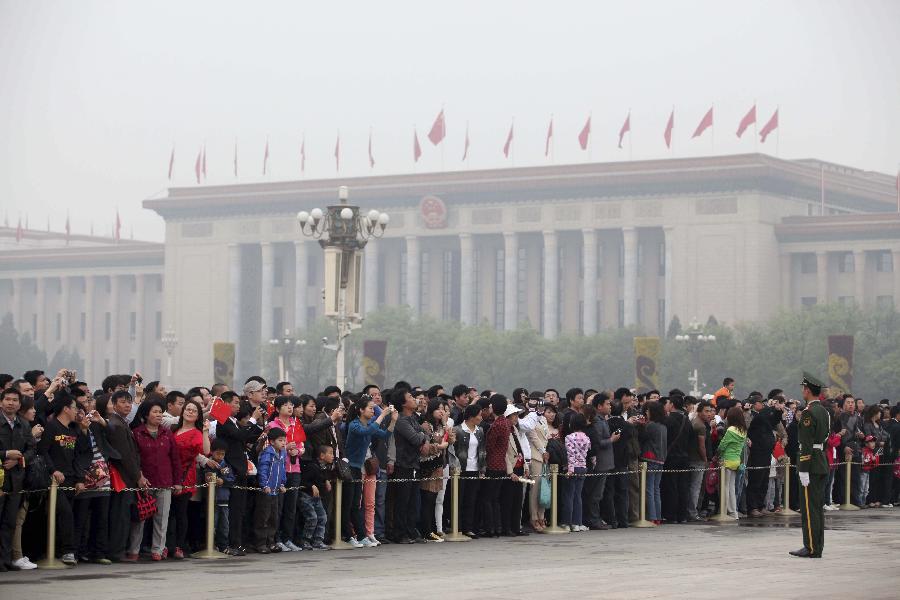 Tourists gather to watch the national flag-raising ceremony in Beijing, capital of China, May 1, 2012. As weather warms, a good many people choose to spend the three-day Labor Day holiday in travelling. (Xinhua/Tian Weitao) 