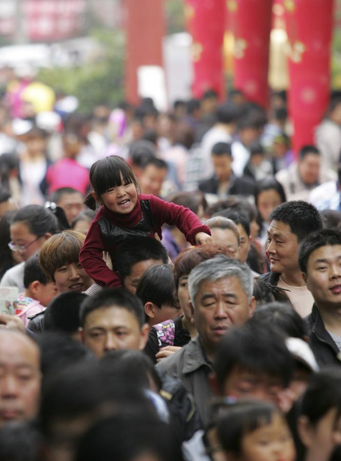 A park is swarmed with tourists in Weifang City, east China's Shangdong Province, April 30, 2012. As weather warms, a good many people choose to spend the three-day Labor Day holiday in travelling. (Xinhua/Zhang Chi) 