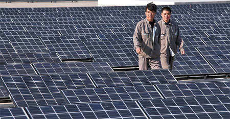 Workers check solar panels at a wastewater treatment facility in Tianjin Eco-City, a joint project between China and Singapore, on April 25.[China Daily]