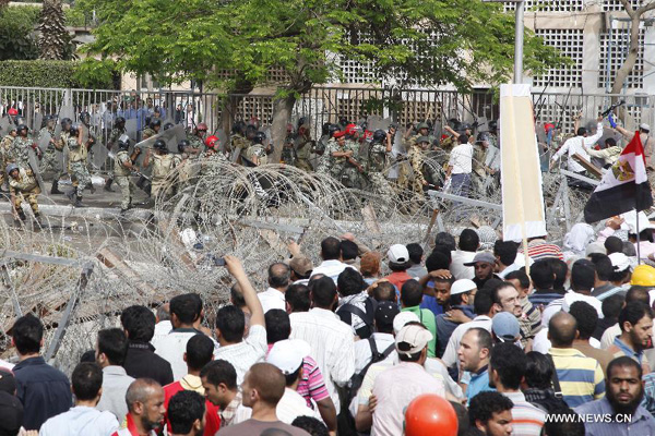 Egyptian demonstrators confront with riot police during protests outside the defense ministry in Cairo's Abbassiya district on May 4, 2012. About 59 people were injured in clashes between troops and anti-military protesters. [Nasser Nouri/Xinhua]