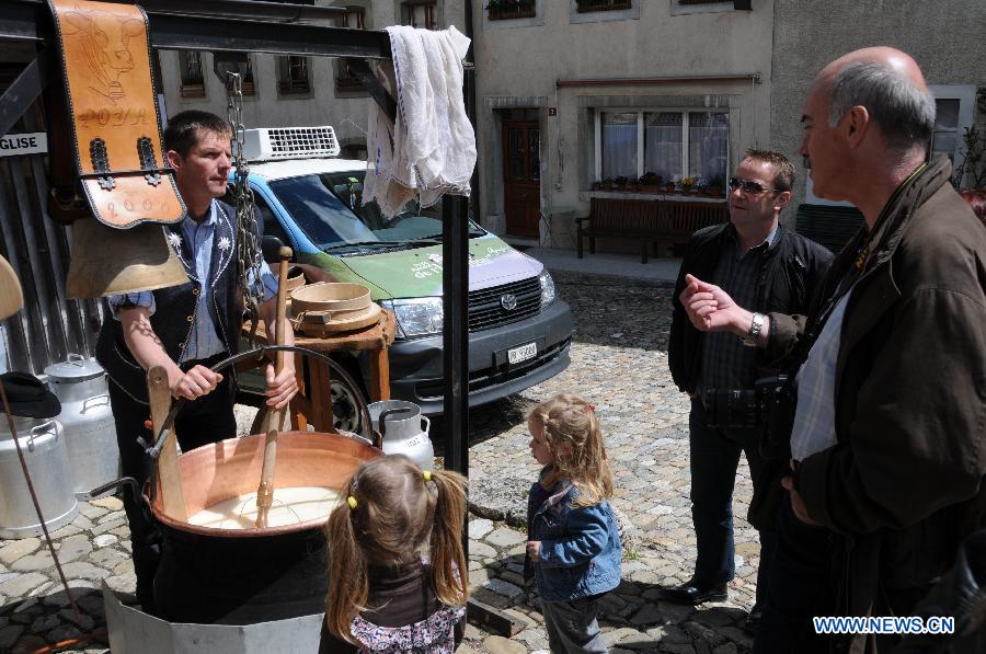 People view cheese making process during the cheese festival in Gruyere, Switzerland, May 6, 2012. [Xinhua/Yang Jingde]