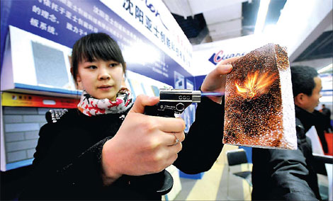 A woman demonstrating a heat-resistant material at a building materials fair in Shenyang, capital of Liaoning province. Many foreign companies are still bullish about China&apos;s property market and have continued to invest in both real estate and building materials.[China Daily]