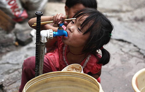 Wang Yaya drinks from a water tap in Guiyang, Guizhou province. [China Daily]