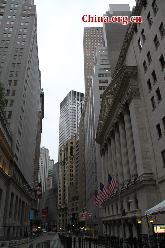 Photo shows a snapshot of Wall Street in New Yorl City, U.S.. Wall Street refers to the financial district of New York City, named after and centered on the eight-block-long street running from Broadway to South Street on the East River in Lower Manhattan. [China.org.cn/Photo by Li Xiaohua]