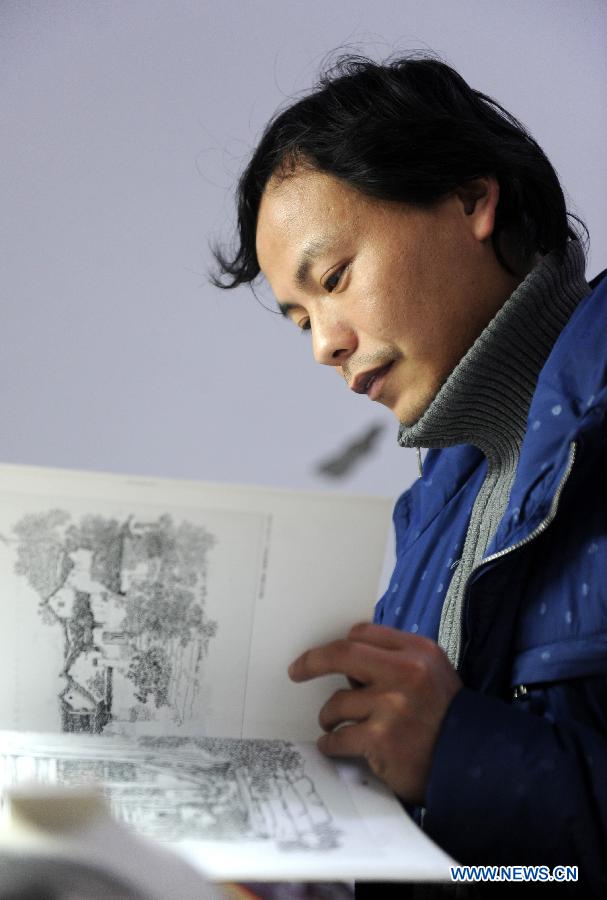 Liu Zhen studies a picture copybook in his studio at the Chengdexuan Porcelain Co.,Ltd, in Jingdezhen of east China's Jiangxi Province, March 8, 2012.