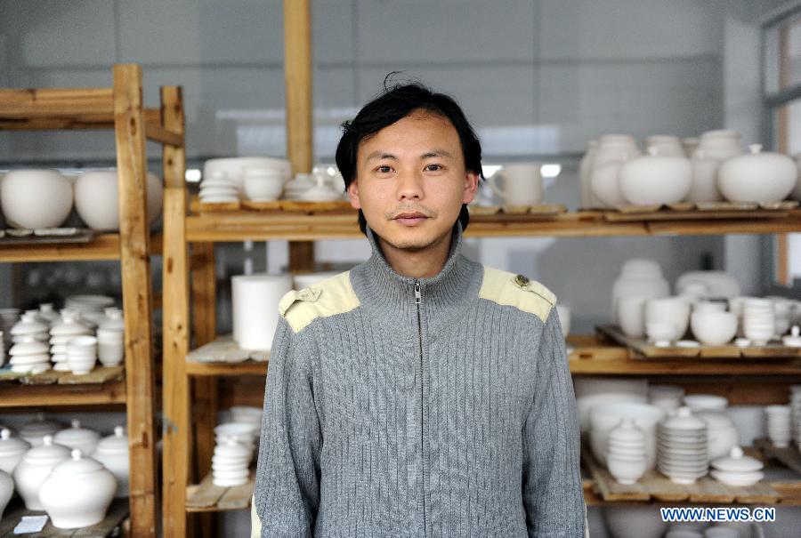 Liu Zhen poses with the porcelain adobes in his studio at the Chengdexuan Porcelain Co.,Ltd, in Jingdezhen of east China's Jiangxi Province, March 8, 2012.