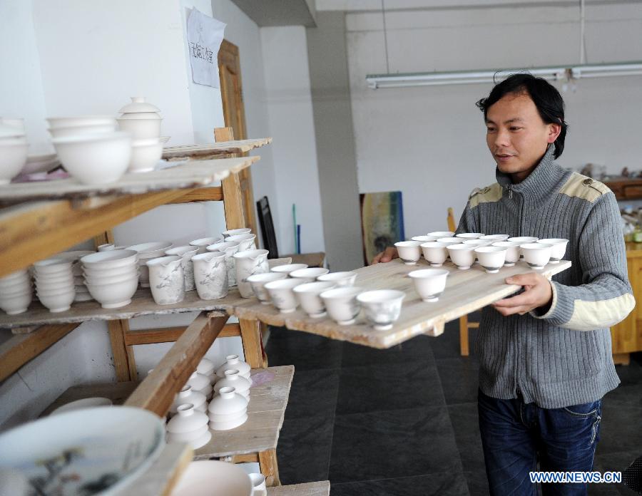 Liu Zhen carries the porcelain adobes in his studio at the Chengdexuan Porcelain Co.,Ltd, in Jingdezhen of east China's Jiangxi Province, March 8, 2012.