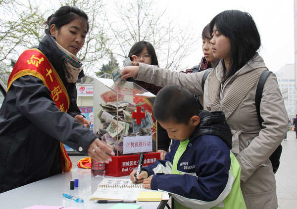 Beijing residents donate money at a Red Cross stand in Xidan for people in Yushu, Qinghai province, three days after the area was hit by a 7.1-magnitude earthquake on April 14, 2010. [ Photo / Xinhua ] 