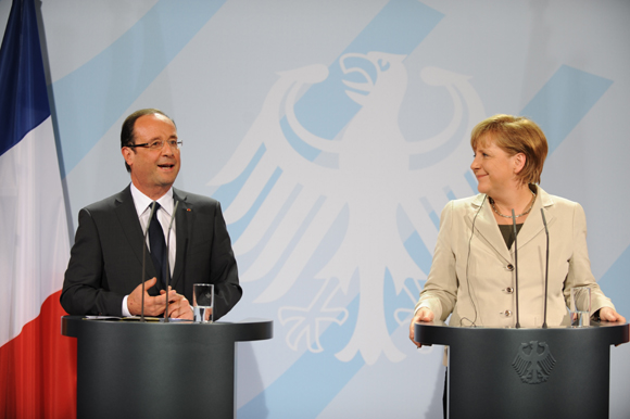 German Chancellor Angela Merkel and French new President Francois Hollande attend a joint news conference on Tuesday. 