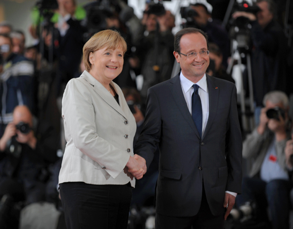 German Chancellor Angela Merkel(L) shakes hands with the French left-wing new president Francois Hollande(R) on Tuesday.