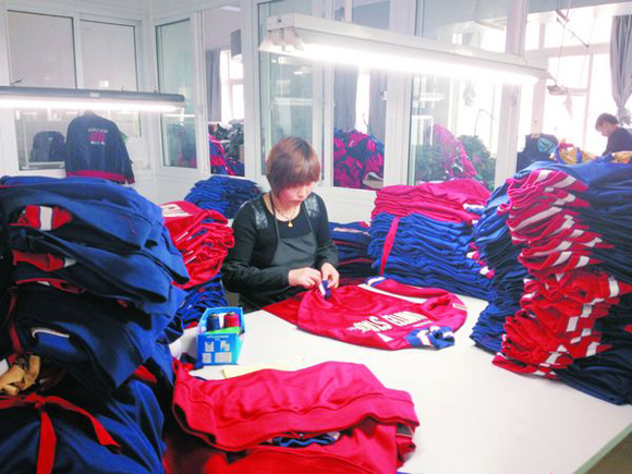 Workers in the Zhejiang Yunlong Co., Ltd process garments for the upcoming 2012 London Olympic Games. 