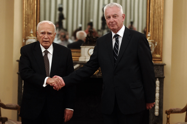 Greek President Carolos Papoulias (L) shakes hands with newly appointed caretaker Prime Minister Panagiotis Pikrammenos (R) in Athens on May 16, 2012. Greece put a senior judge in charge of an emergency government to lead it to new elections on June 17 and bankers sought to calm public fears after the president said political chaos risked causing panic and a run on deposits. 