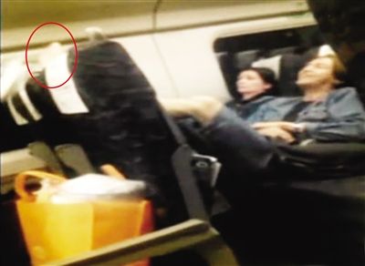 5月14日晚，沈阳北开往北京的列车上，俄籍男子奥列格将赤脚高抬搭在前排乘客的坐椅上。图中红圈内为赤脚所在的位置。视频截图