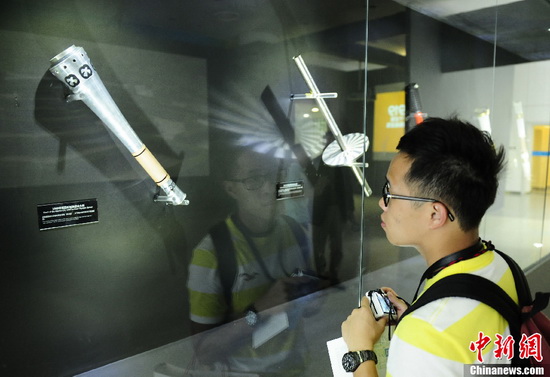 A tourist looks at an Olympic torch in the Olympic torch exhibition inside the 'Water Cube' in Beijing on May 16. (CNS Photo / Hou Yu)