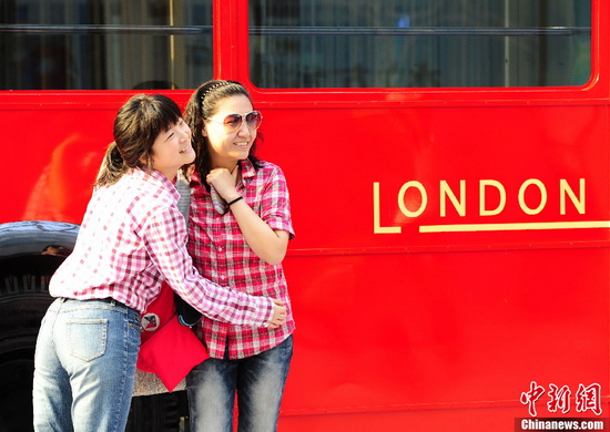 Two tourists pose for photo on the 'London Style Street' in the Water Cube in Beijing on May 16. (CNS Photo / Hou Yu) 