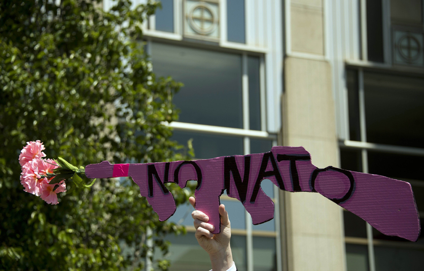 A demonstrator with Code Pink holds up a placard in the shape of an AK-47 outside the Chicago Obama Headquarters in Chicago, Illinois, May 17, 2012, as peace activists march through the street demanding an end to NATO violence ahead of the NATO 2012 Summit. After a decade in Afghanistan, NATO leaders gather for a key summit May 20, 2012, hoping for a show of unity in the final two years of combat -- even though allies are eager to bring troops home. 