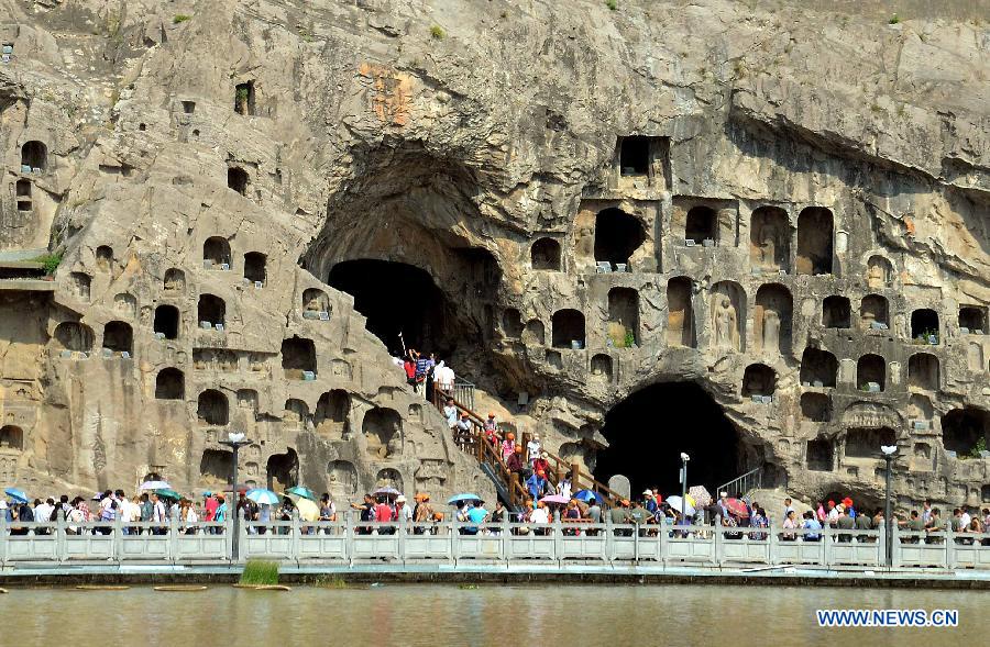 People visit the scenic area of the Longmen Grottoes in Luoyang, central China's Henan Province, May 19, 2012. Scenic spots across the country see lots of visitors on Saturday, the second China Tourism Day. (Xinhua/Wang Song) 