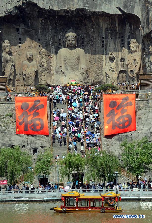 Visitors take part in a prayer service at the Fengxian Temple in the scenic area of the Longmen Grottoes in Luoyang, central China's Henan Province, May 19, 2012. Scenic spots across the country see lots of visitors on Saturday, the second China Tourism Day. (Xinhua/Wang Song) 