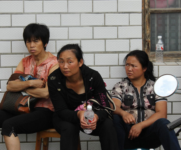 Family members of victims of a deadly tunnel blast wait near the Baimianshan tunnel, Yanling county, Central China's Hunan province, on Sunday. The explosion on Saturday killed 20 people. [Photo / for China Daily ]