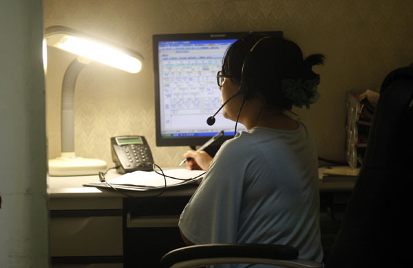A staff member at the Beijing Suicide Research and Prevention Center receives a call on the center's hotline. The center is the first in Beijing to provide a free suicide intervention service. [Photo / China Daily ]