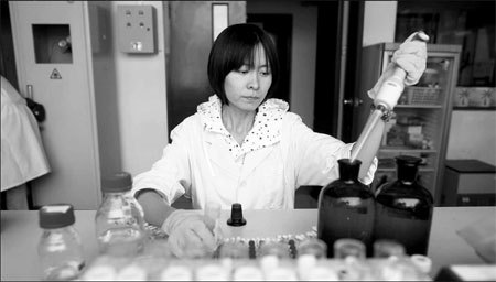 A staff member from Beijing Waterworks Group tests a water sample before it flows to the pipeline. New quality standards for drinking water will come into effect on July 1. [China Daily] 