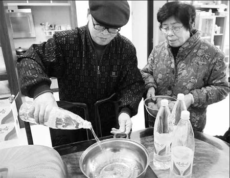 Wei Shubing (left) and his wife must use bottled water for cooking after Longjiang River was contaminated by cadmium in January, affecting residents of Liuzhou city in the Guangxi Zhuang autonomous region. [China Daily] 