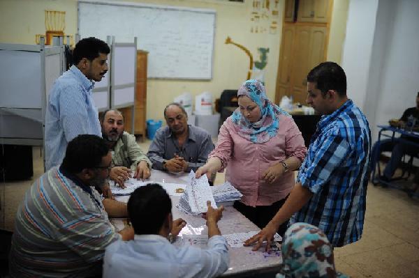 Electorial officials count the votes at a polling station in Cairo on May 24, 2012, after polls closed in country's landmark presidential election. Around 50 million eligible voters were called to cast their ballots today in 13,000 polling stations around the country. [Xinhua/Qin Haishi]