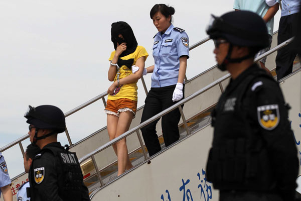 Suspects in an international telecom fraud arrived in Beijing on Thursday. The 126 men and women were handed over to Chinese police by Malaysian and Thai police, the Ministry of Public Security said. [Photo / China Daily ]