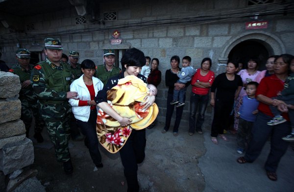 A baby is rescued from a child trafficking gang in Putian city, East China's Fujian province, Nov 30, 2011. Chinese police in 10 provincial-level regions have jointly cracked two child trafficking gangs that were deemed 'seriously harmful,' arresting 608 suspects and rescuing 178 children, according to the Ministry of Public Security.[Photo/Xinhua]