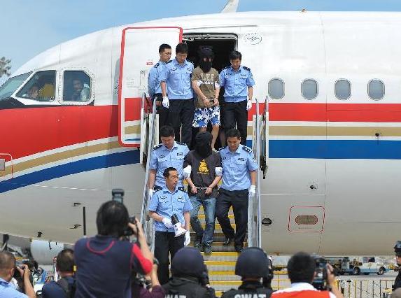 Suspects of a transnational telephone fraud are transferred to the Chinese mainland at Beijing Capital International Airport on Thursday. [Photo / Xinhua ]