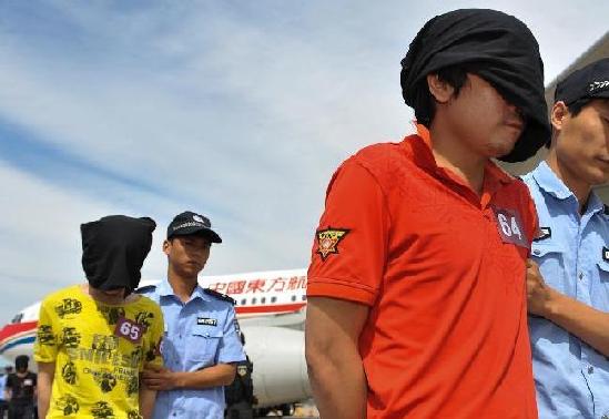 Suspects of a transnational telephone fraud are transferred to the Chinese mainland at Beijing Capital International Airport on Thursday. [Photo / Xinhua ]
