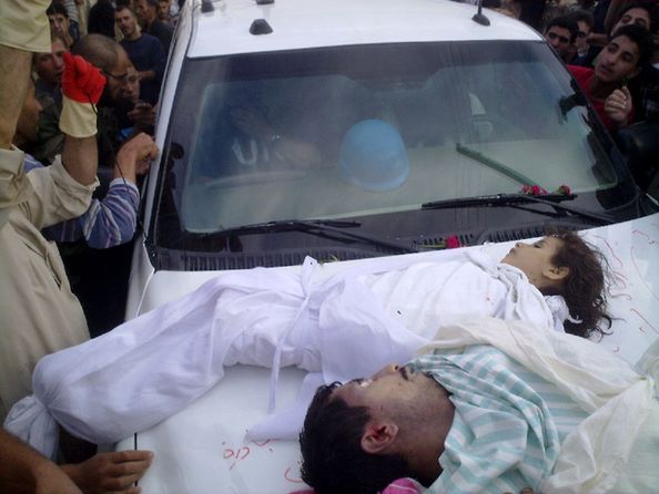 A handout picture released by the Syrian opposition's Shaam News Network shows Syrians gathering around the car of UN observers after placing the bodies of a girl and a man on top of their vehicle upon their arrival in the Syrian town of Houla on May 26, 2012. [Xinhua]