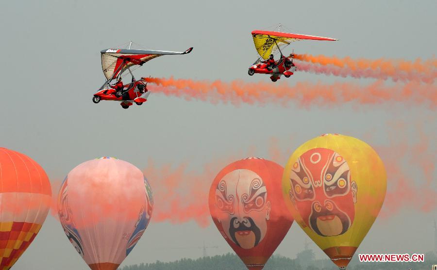 The aviation sports amateurs perform in the air during a show at the 4th China (Anyang) International Aviation Sports Festival in Anyang, central China's Henan Province, May 26, 2012. The festival kicked off here on Saturday, with the participation of more than 400 aviation sports amateurs all over the world. (Xinhua/Zhu Xiang) 