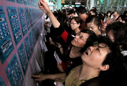 Anxious-looking parents - probably in horror at having an unmarried child - scan message board profiles to find a date for their offspring. [ Photo / Shanghai Daily ]