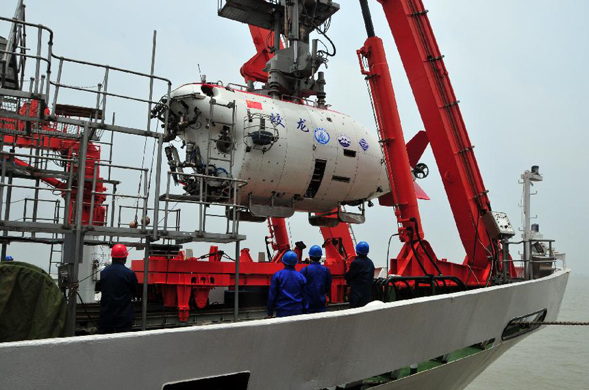 Workers move China's manned submersible Jiaolong into water in Jiangyin, east China's Jiangsu Province, June 1, 2012. The Jiaolong on Friday held two diving practices for its challenge of a 7,000-meter dive to the Mariana Trench slated for June 3.