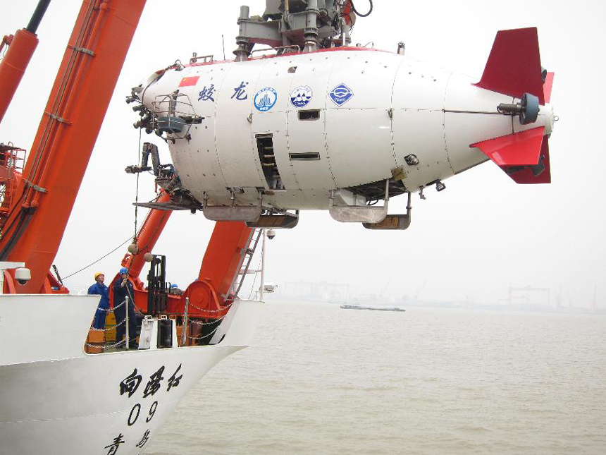 Workers move China's manned submersible Jiaolong into water in Jiangyin, east China's Jiangsu Province, June 1, 2012. The Jiaolong on Friday held two diving practices for its challenge of a 7,000-meter dive to the Mariana Trench slated for June 3.