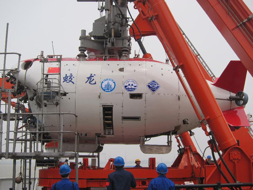 Workers move China's manned submersible Jiaolong into water in Jiangyin, east China's Jiangsu Province, June 1, 2012. The Jiaolong on Friday held two diving practices for its challenge of a 7,000-meter dive to the Mariana Trench slated for June 3.