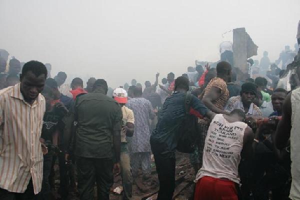 People gather at the site of a plane crash near the Lagos airport in Nigeria, June 3, 2012. A passenger plane carrying 153 people crashed into a two-storey building in Nigeria's southwestern Lagos State on Sunday, killing all the people on board and 40 others on the ground. At least four Chinese were among the passengers, the Chinese Embassy in the West African country has confirmed. [Ezekiel Taiwo/Xinhua]