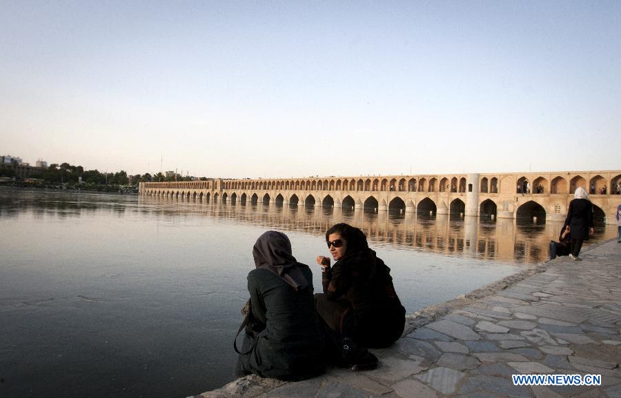 Iranian women sit beside Zayanderood river in Isfahan, central Iran, May 31, 2012. Isfahan, the third largest city in Iran, is a world famous historical city well-known for ancient architectures, fine carpets, silver filigree and handicrafts. (Xinhua/Ahmad Halabisaz) 