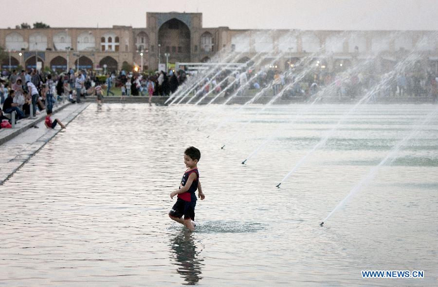 A boy plays in water at Naghshe Jahan square in Isfahan, central Iran, May 31, 2012. Isfahan, the third largest city in Iran, is a world famous historical city well-known for ancient architectures, fine carpets, silver filigree and handicrafts. (Xinhua/Ahmad Halabisaz) 