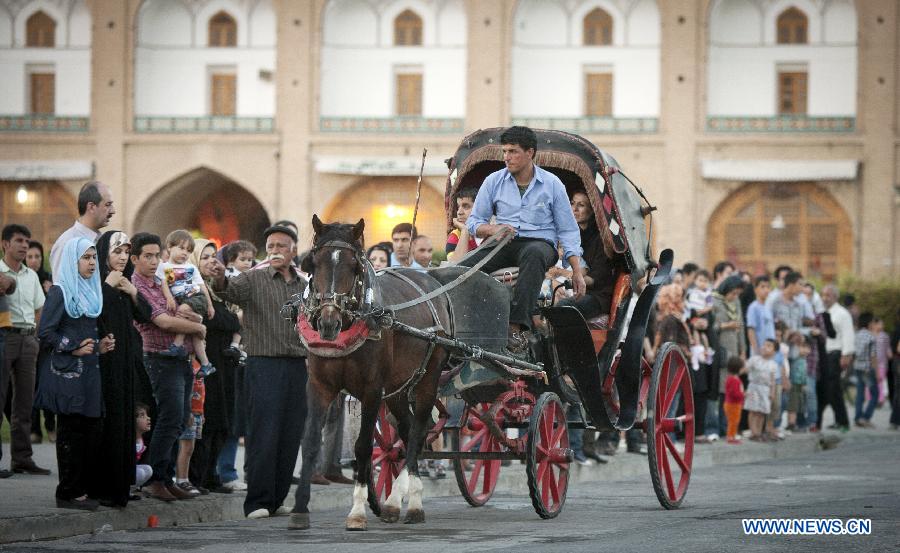 A horse-dragged carriage with tourists aboard is seen at Naghshe Jahan square in Isfahan, central Iran, May 31, 2012. Isfahan, the third largest city in Iran, is a world famous historical city well-known for ancient architectures, fine carpets, silver filigree and handicrafts. (Xinhua/Ahmad Halabisaz) 