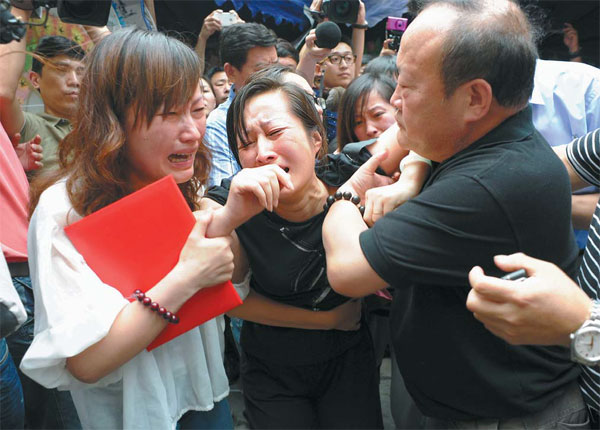 Bus driver Wu Bin's wife, Wang Lizhen (center), and relatives are overwhelmed by grief on Sunday. Wu's bravery captured the public's imagination. [ Photo / China Daily ]