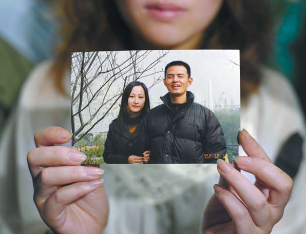 Wang's sister, Wang Limin, holds a photo of Wu and his wife. 