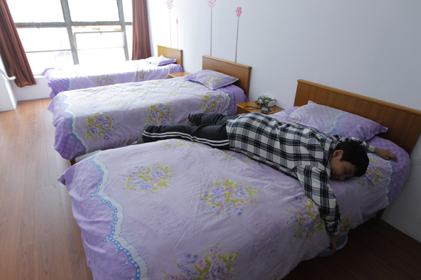 Xue Hongtian rests on his bed before going to school. [ Photo / China Daily ]