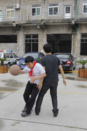 Xue Hongtian plays basketball with a staff member recently at the Yangpu district homeless assistance station in Shanghai. [ Photo / China Daily ]